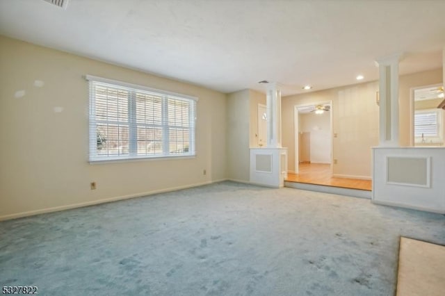 unfurnished living room with carpet flooring, ceiling fan, and ornate columns