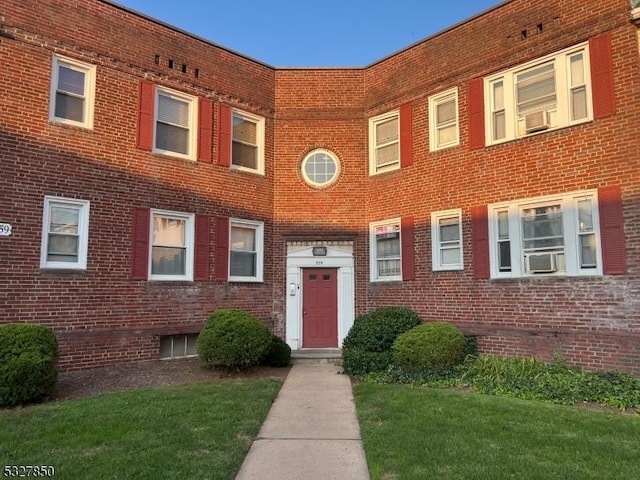 view of front of property featuring a front yard and cooling unit