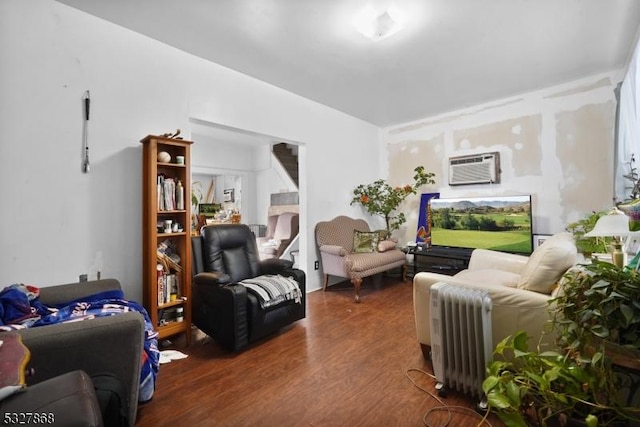 living room featuring an AC wall unit and dark wood-type flooring