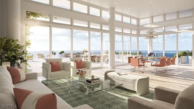 sunroom / solarium featuring a water view and a notable chandelier