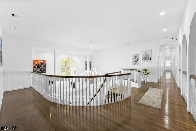 hall with dark hardwood / wood-style floors and a notable chandelier