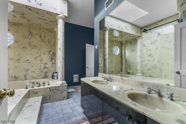 bathroom with tile patterned flooring, vanity, a tub, and a skylight