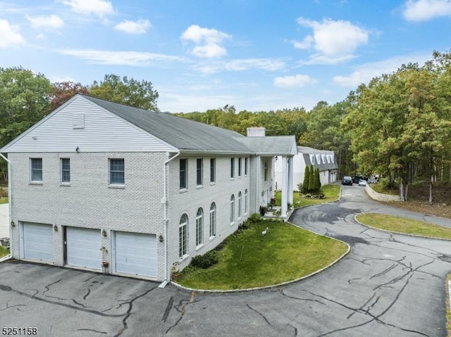 view of property exterior with a garage and a lawn