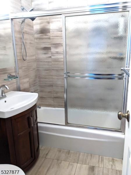 full bathroom with shower / bath combination with glass door, vanity, and toilet