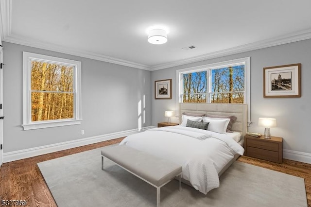 bedroom featuring multiple windows, crown molding, and dark hardwood / wood-style flooring