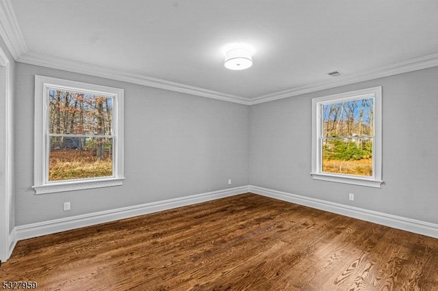 unfurnished room with crown molding, plenty of natural light, and dark hardwood / wood-style floors