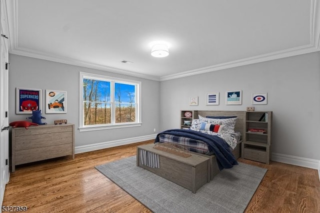 bedroom with hardwood / wood-style floors and crown molding