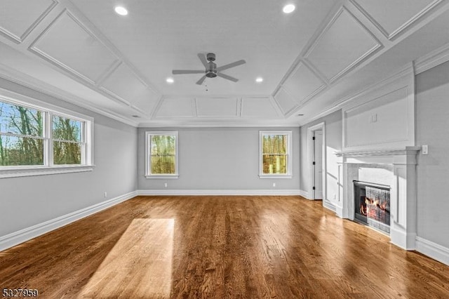 unfurnished living room featuring ceiling fan, ornamental molding, and hardwood / wood-style flooring