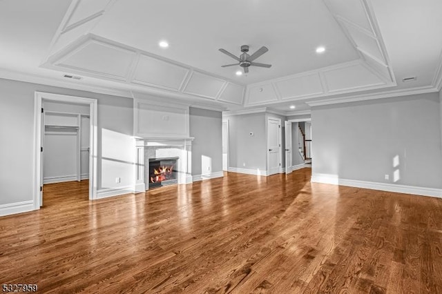 unfurnished living room featuring hardwood / wood-style flooring, ceiling fan, and ornamental molding