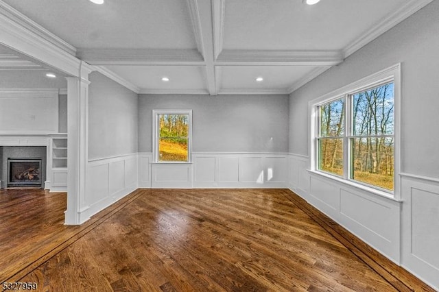 unfurnished dining area featuring wood-type flooring, crown molding, and beam ceiling