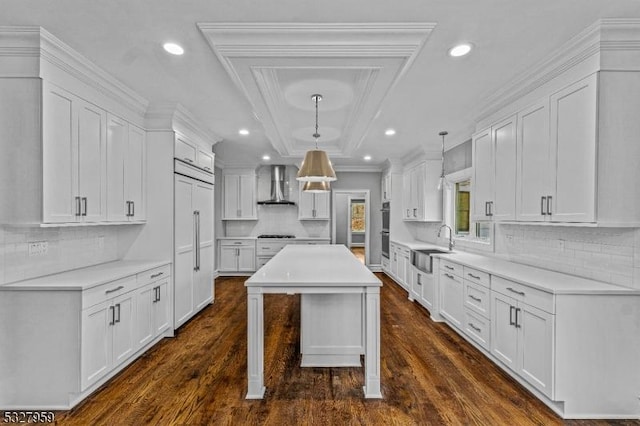 kitchen with white cabinets, dark wood-type flooring, and wall chimney range hood