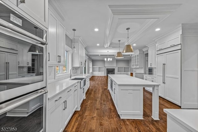 kitchen featuring white cabinets, decorative light fixtures, and a kitchen island