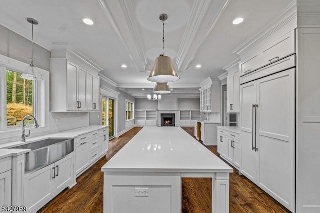 kitchen with white cabinetry, sink, and hanging light fixtures