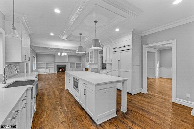 kitchen featuring a kitchen island, white cabinetry, dark wood-type flooring, and sink