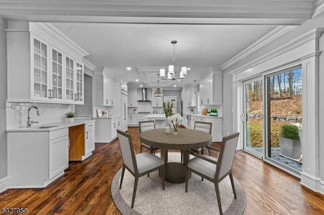 dining room featuring ornamental molding, an inviting chandelier, dark wood-type flooring, and sink