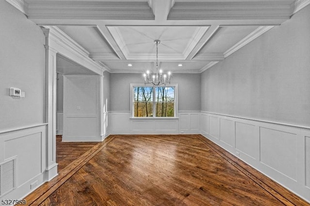 unfurnished dining area featuring coffered ceiling, crown molding, dark hardwood / wood-style floors, a notable chandelier, and beam ceiling