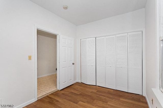 unfurnished bedroom with a closet and hardwood / wood-style flooring