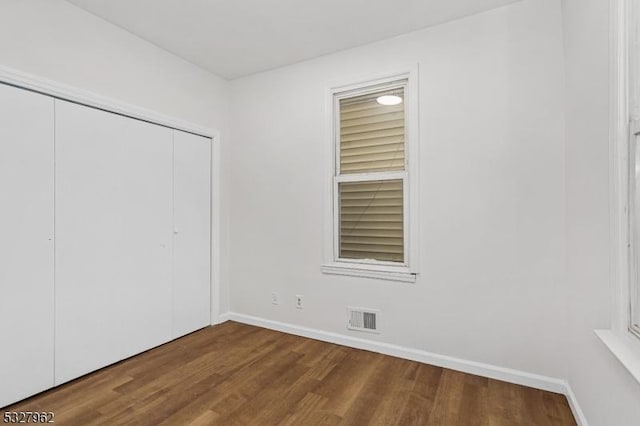 unfurnished bedroom featuring wood-type flooring and a closet