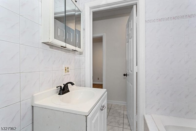 bathroom featuring vanity, a bath, and tile walls