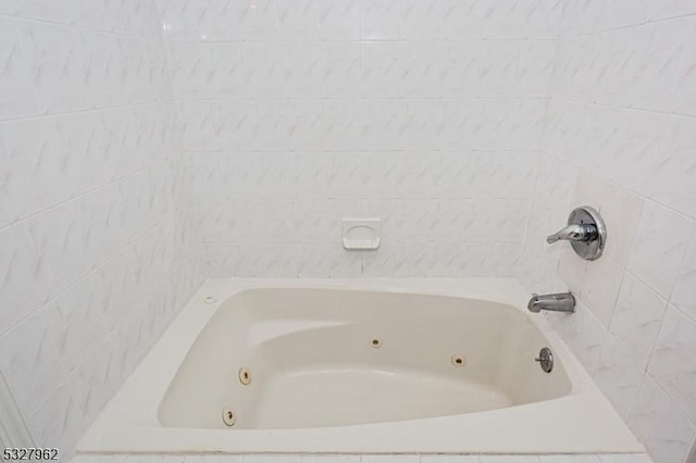 bathroom with a relaxing tiled tub