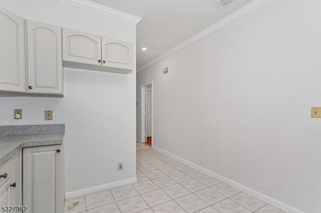 kitchen featuring white cabinets, light tile patterned flooring, and ornamental molding