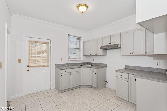 kitchen with light tile patterned floors, ornamental molding, and sink