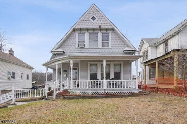 view of front facade with cooling unit, a front lawn, and covered porch