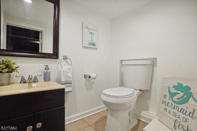 bathroom with toilet, vanity, and tile patterned floors