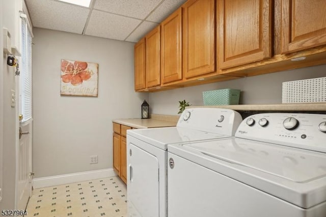 clothes washing area featuring washer and dryer and cabinets