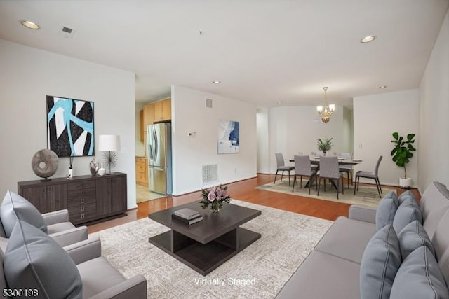 living room with wood-type flooring and an inviting chandelier