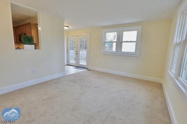 spare room with french doors and light carpet