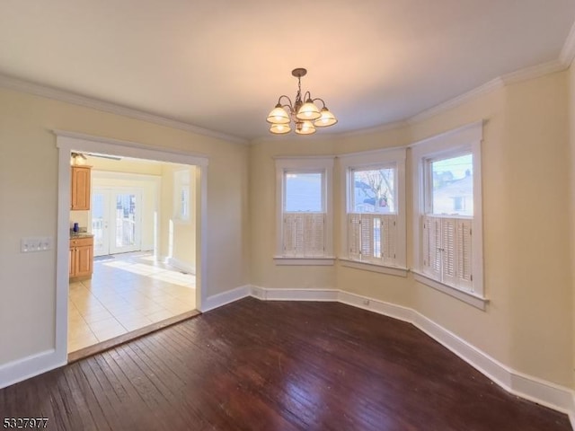 empty room featuring ornamental molding, a notable chandelier, and light wood-type flooring