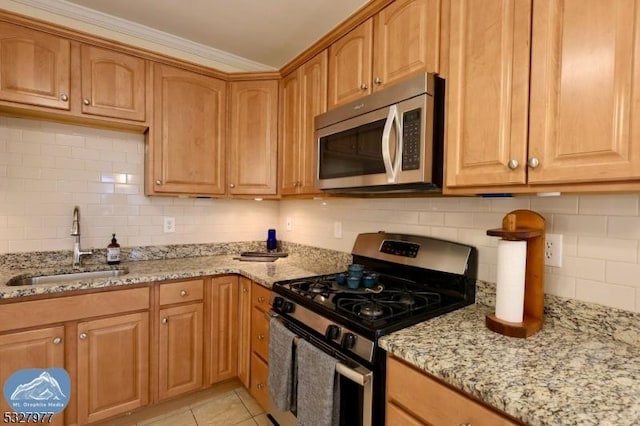 kitchen with appliances with stainless steel finishes, tasteful backsplash, sink, light tile patterned floors, and light stone counters