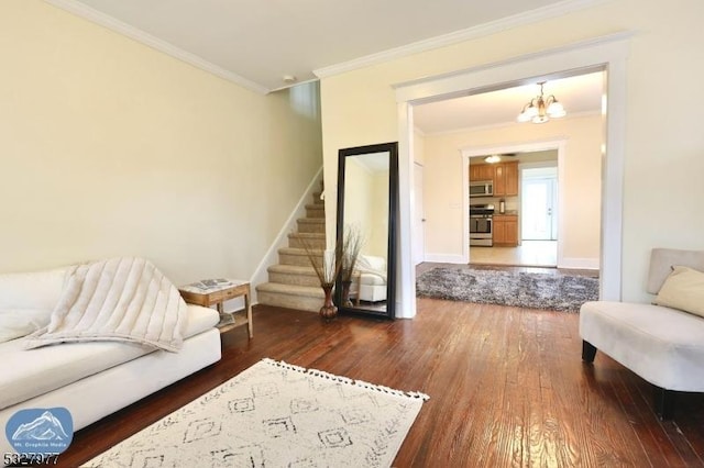 sitting room with dark hardwood / wood-style flooring, ornamental molding, and an inviting chandelier