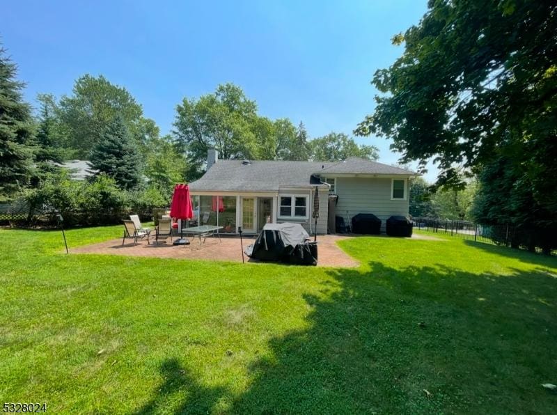 rear view of property with a patio and a yard