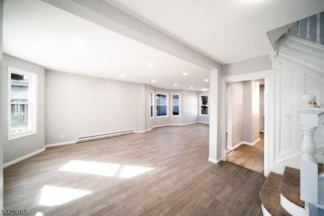 unfurnished living room with dark hardwood / wood-style floors and baseboard heating