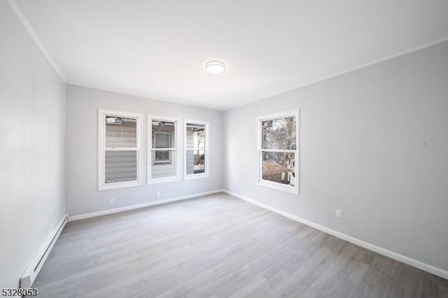 empty room with hardwood / wood-style floors and baseboard heating