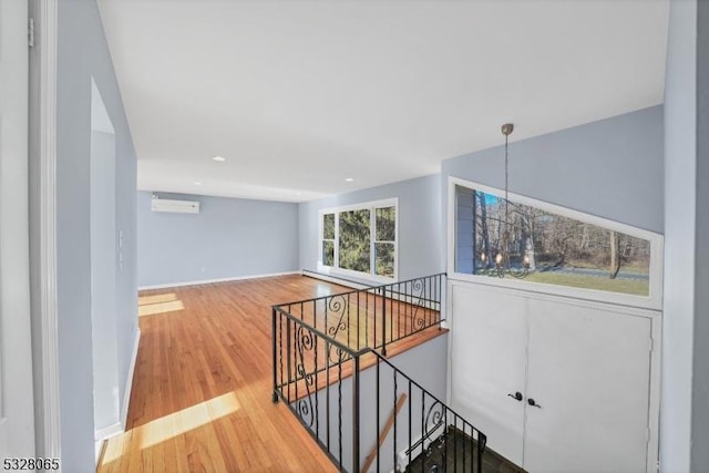 hallway featuring a wall mounted AC and wood-type flooring