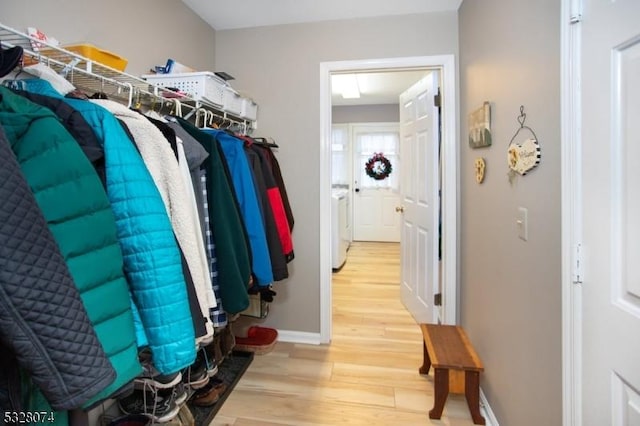 spacious closet featuring hardwood / wood-style floors and washing machine and dryer