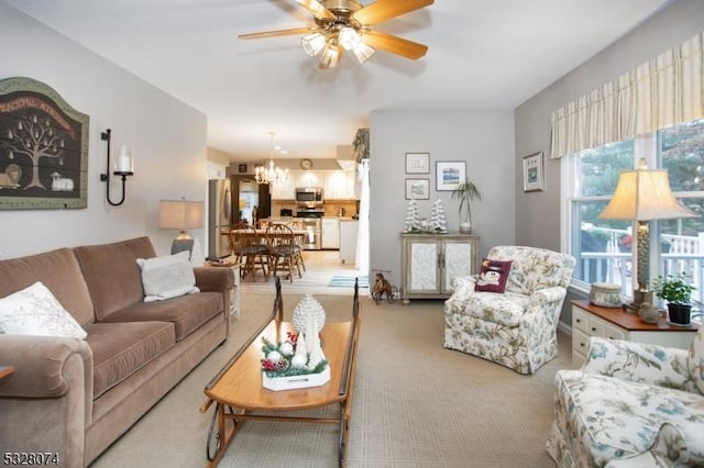 living room with light carpet and ceiling fan with notable chandelier