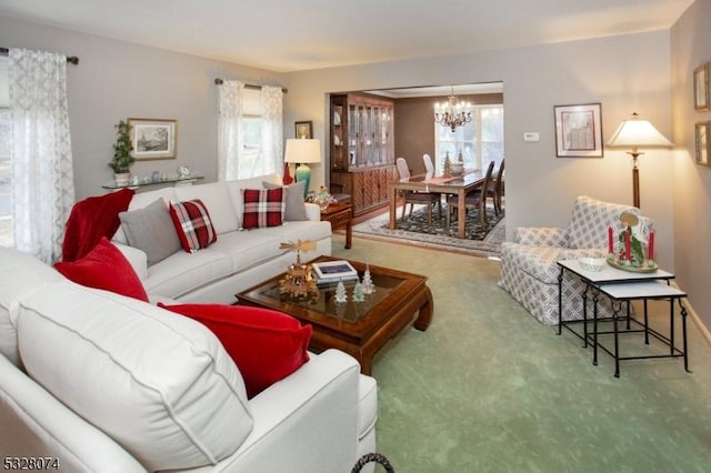 carpeted living room featuring plenty of natural light and a chandelier