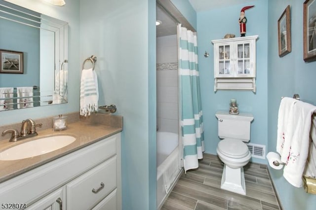 full bathroom featuring vanity, shower / bath combination with curtain, and toilet