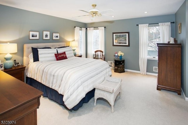 bedroom featuring light carpet, multiple windows, and ceiling fan