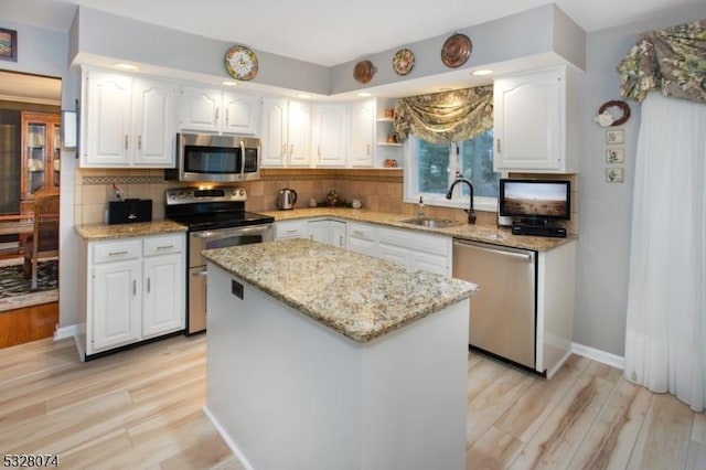 kitchen with a center island, sink, white cabinetry, and stainless steel appliances