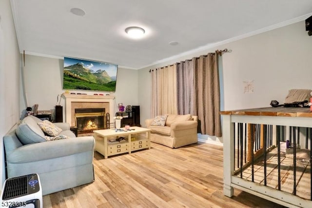 living room with a tile fireplace, crown molding, and wood-type flooring