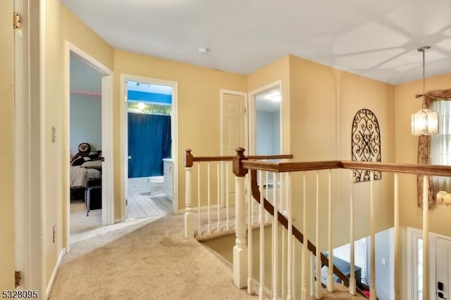 hall with a chandelier and carpet flooring