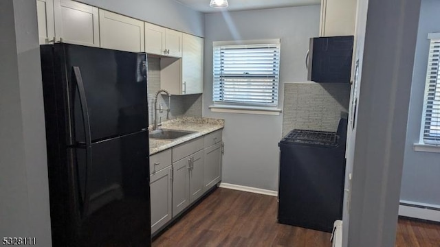 kitchen featuring black fridge, baseboard heating, sink, and dark wood-type flooring