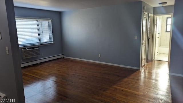 spare room featuring a wall unit AC, a wealth of natural light, dark hardwood / wood-style flooring, and a baseboard radiator