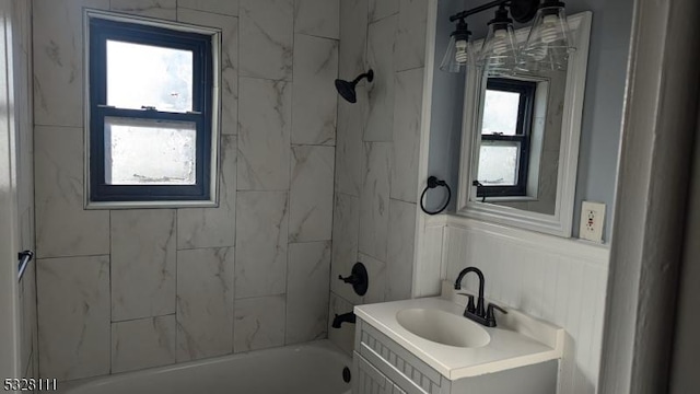 bathroom featuring vanity and tiled shower / bath