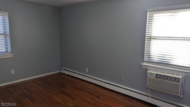 empty room with a baseboard radiator and dark hardwood / wood-style floors